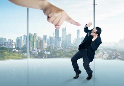 Mike Dadson can help with feelings of shame and guilt Giant finger pointing at guilty, ashamed executive in office with city view